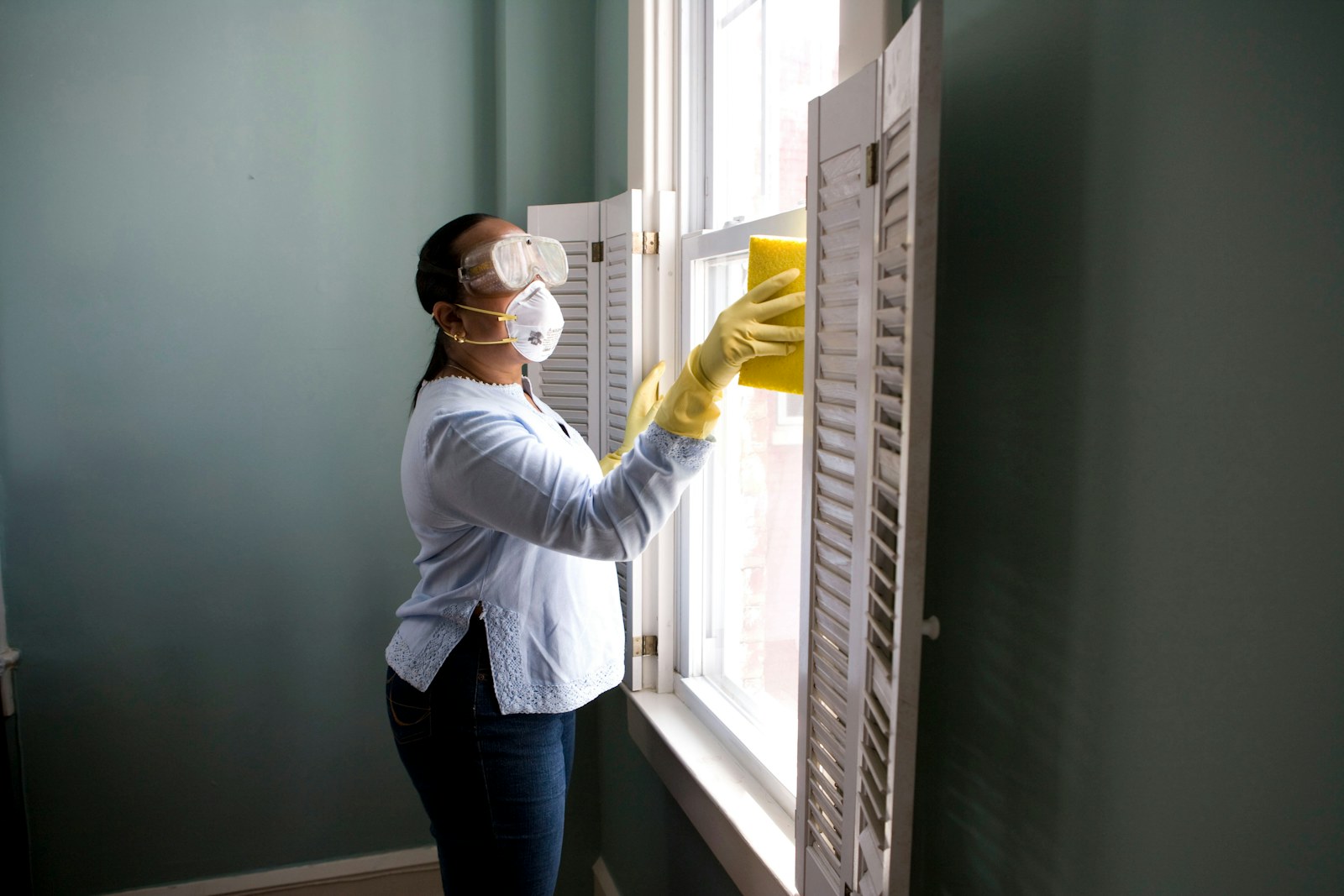 A person cleaning a light-filled living space